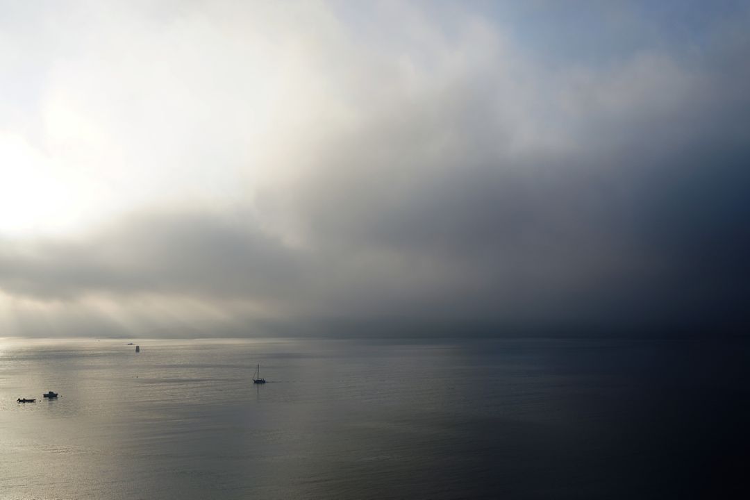 Misty Morning Landscape Over Calm Ocean with Boats - Free Images, Stock Photos and Pictures on Pikwizard.com