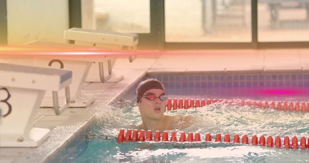 Focused Swimmer Training in Competition Pool Near Lane Divider
