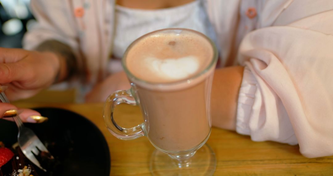 Woman Enjoying Frothy Hot Chocolate with Dessert in Cozy Setting - Free Images, Stock Photos and Pictures on Pikwizard.com