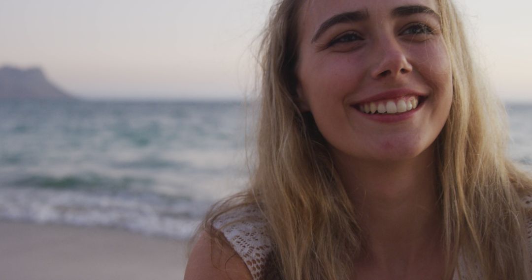 Smiling Woman Enjoying Beach during Sunset - Free Images, Stock Photos and Pictures on Pikwizard.com