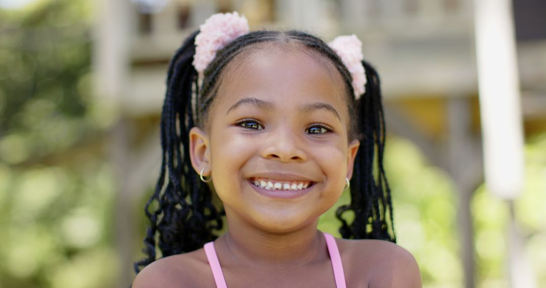 Smiling African American Girl Outdoors with Pink Hair Ties - Free Images, Stock Photos and Pictures on Pikwizard.com