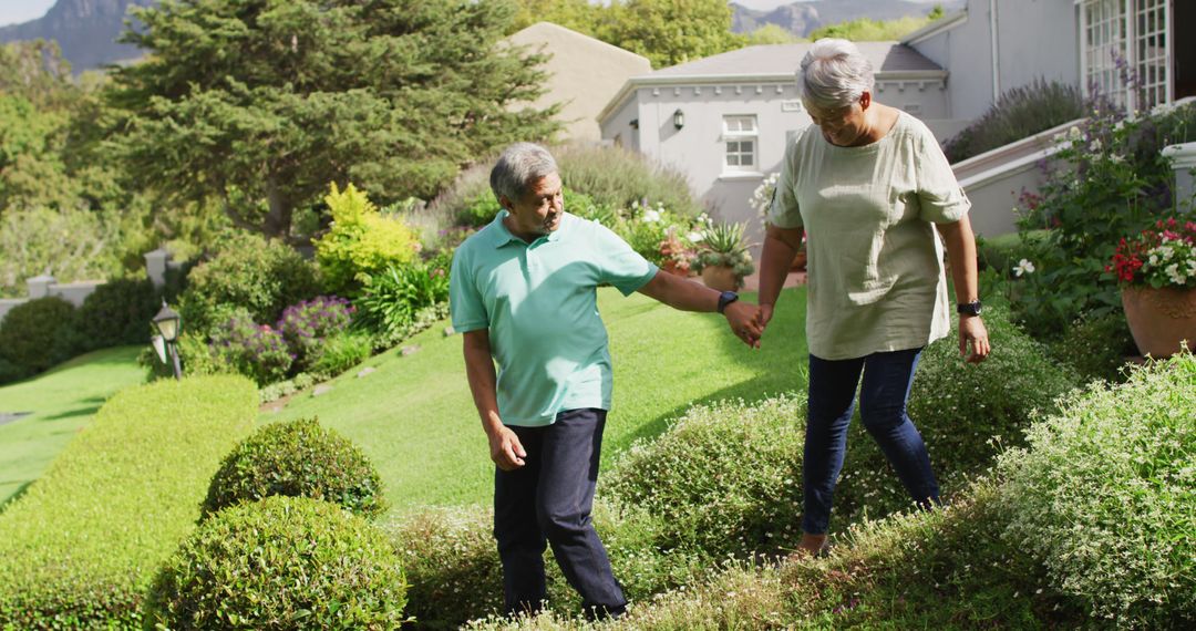 Image of happy biracial senior couple holding hands and walking in garden - Free Images, Stock Photos and Pictures on Pikwizard.com