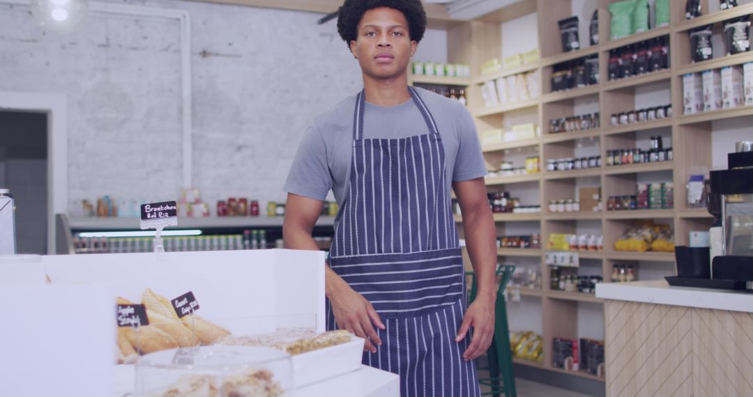 Young Baker Standing in Artisan Bakery with Fresh Pastries