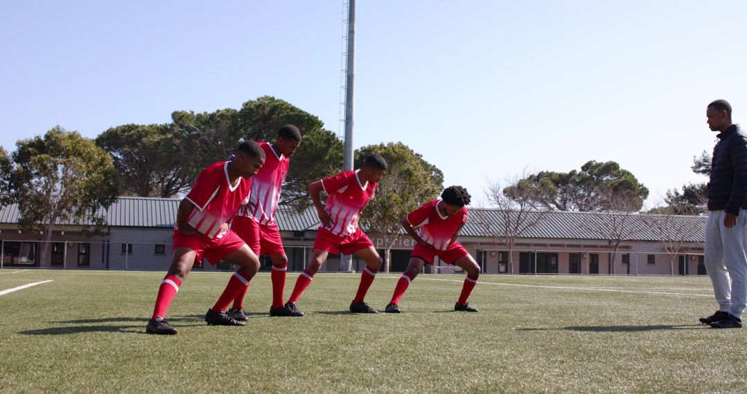 Youth Soccer Players Warming Up with Coach Guidance on Field