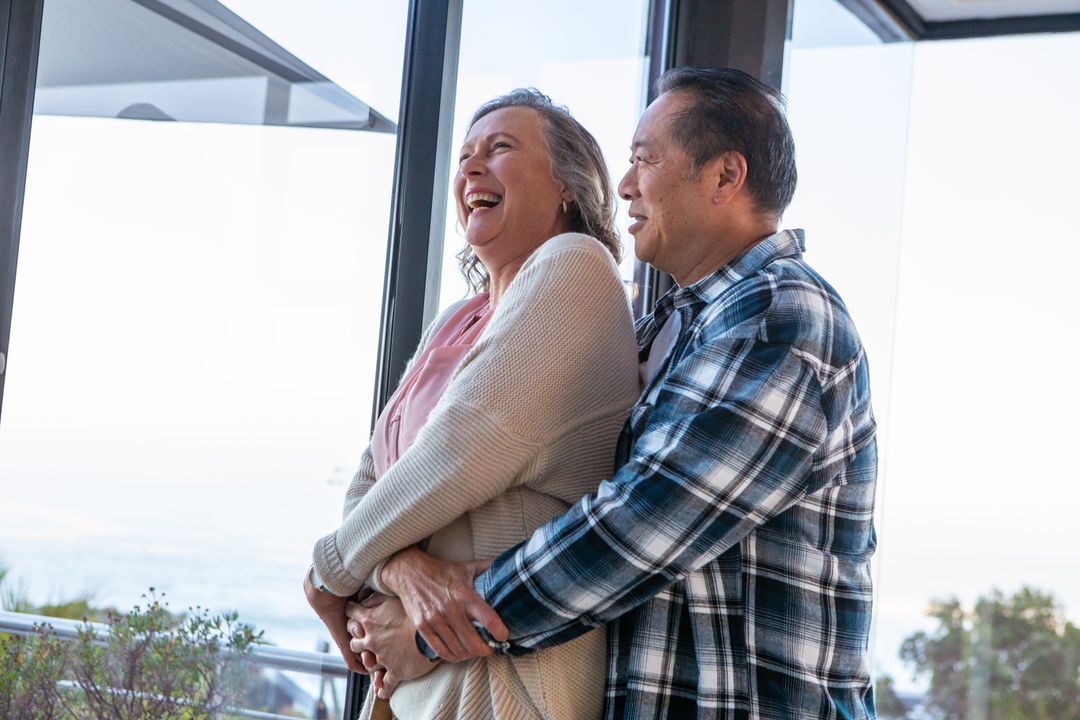 Diverse Couple Embracing on Oceanfront Balcony