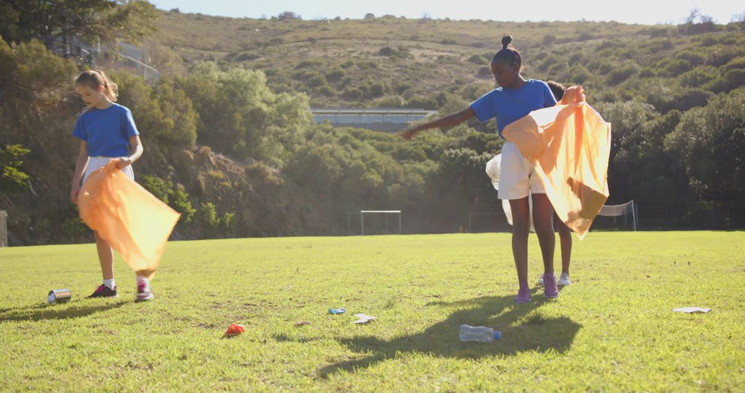 Girls Collecting Litter in a Soccer Field during Community Clean-up Drive