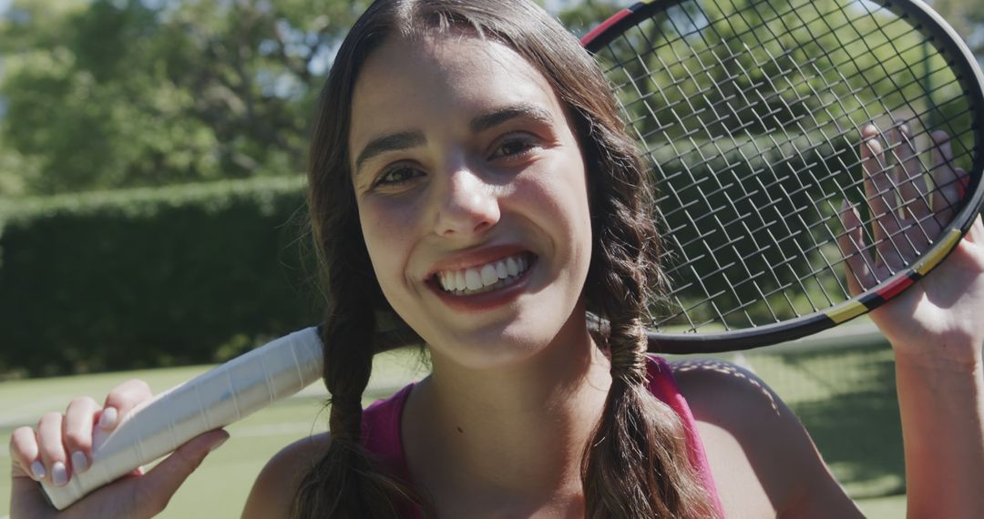 Young Woman Smiling While Holding Tennis Racket Outdoors - Free Images, Stock Photos and Pictures on Pikwizard.com