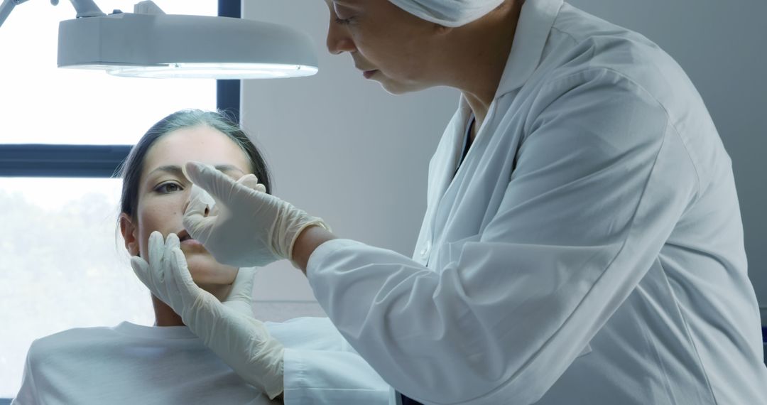 Dermatologist Examining Female Patient Under Medical Light - Free Images, Stock Photos and Pictures on Pikwizard.com