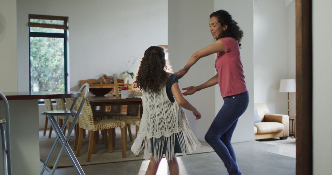 Happy biracial mother and daughter dancing in living room - Free Images, Stock Photos and Pictures on Pikwizard.com