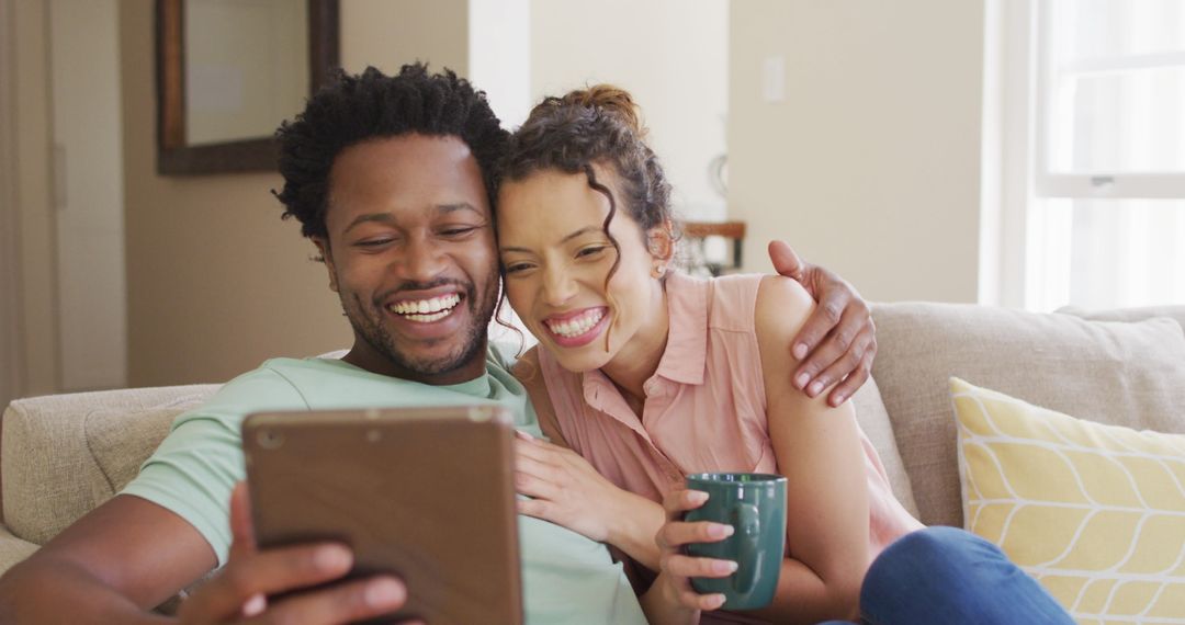 Happy Couple Using Tablet on Sofa During Video Call