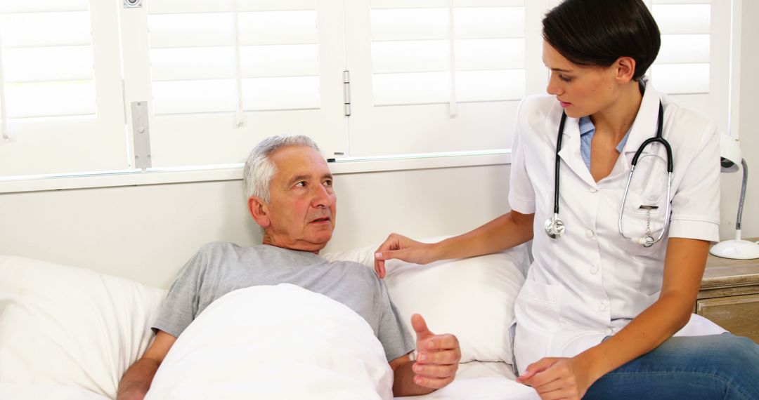 Nurse comforting elderly man in hospital bed, compassionate care - Free Images, Stock Photos and Pictures on Pikwizard.com