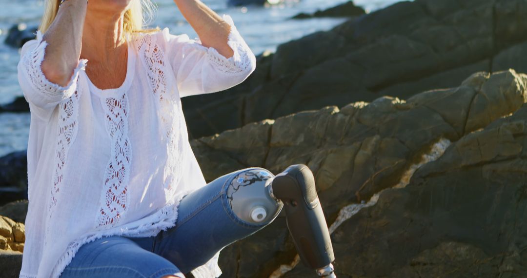 Woman with Prosthetic Leg Enjoying Nature Near Rocky Coastline - Free Images, Stock Photos and Pictures on Pikwizard.com