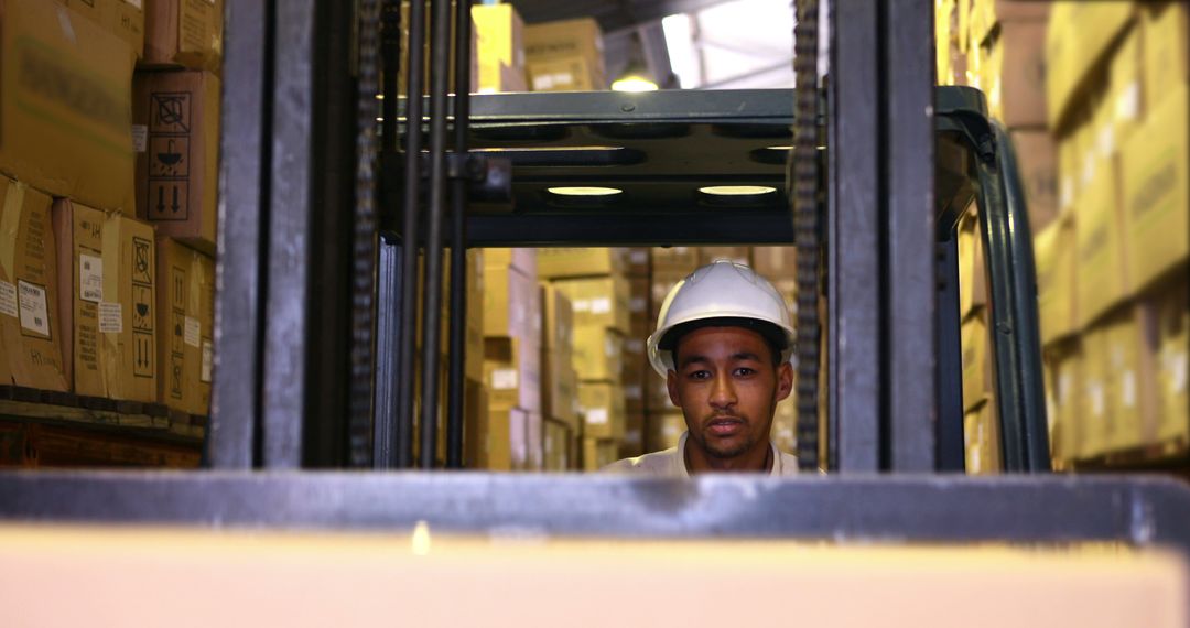 Warehouse Worker Operating Forklift Among Stacked Boxes - Free Images, Stock Photos and Pictures on Pikwizard.com