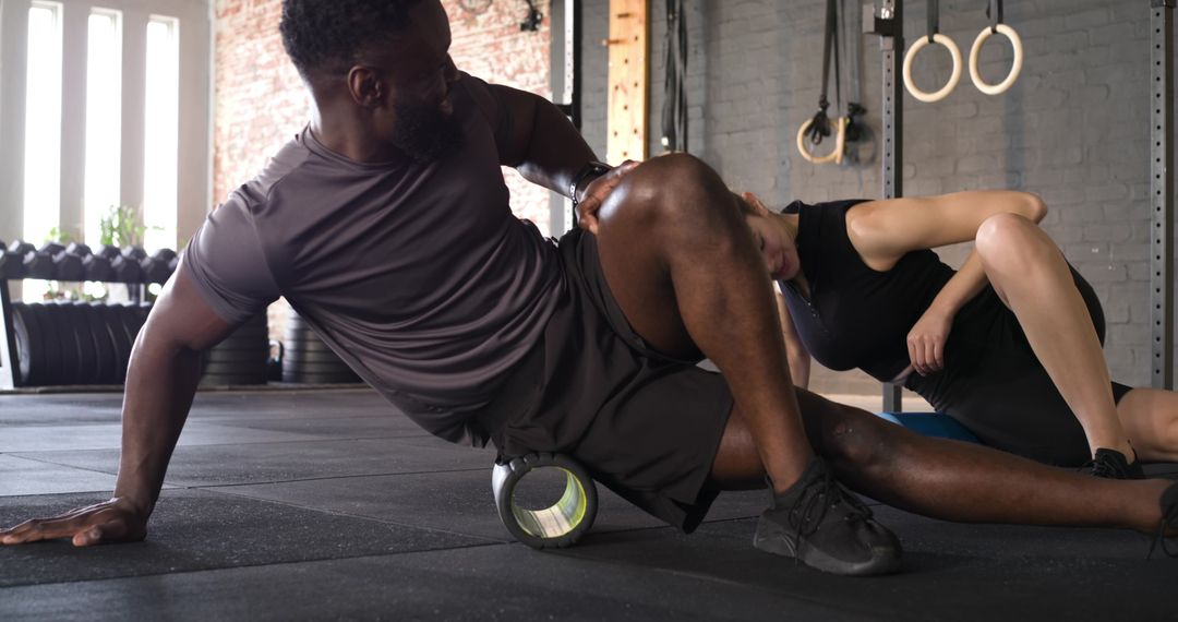 Diverse Workout Partners Practicing Foam Rolling Therapy