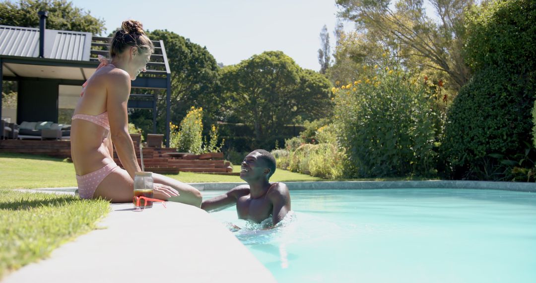 Diverse Couple Relaxing by Pool in Sunny Backyard Oasis