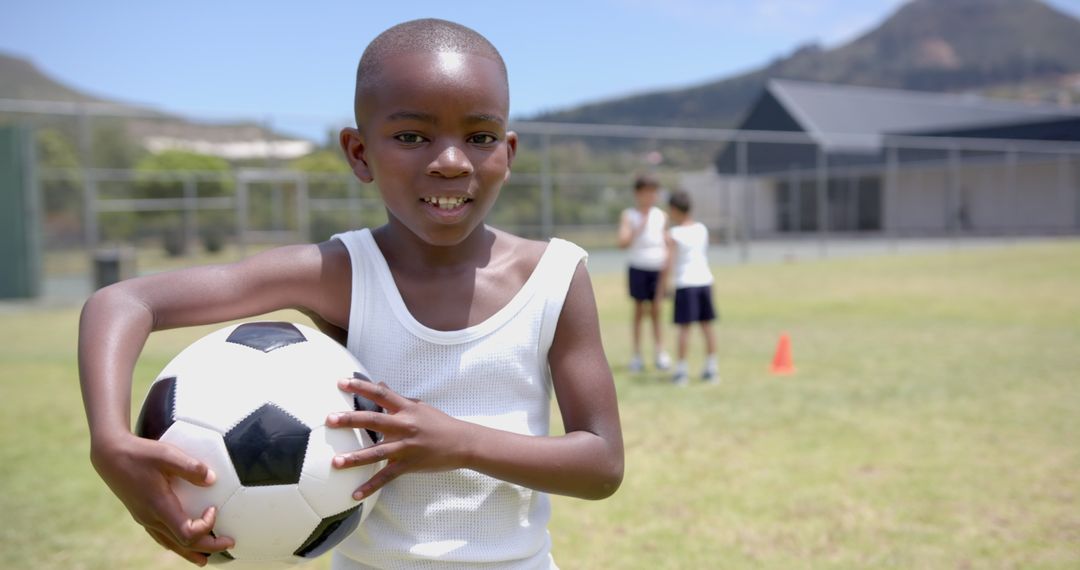 Child Holding Soccer Ball Smiling Outdoor Field