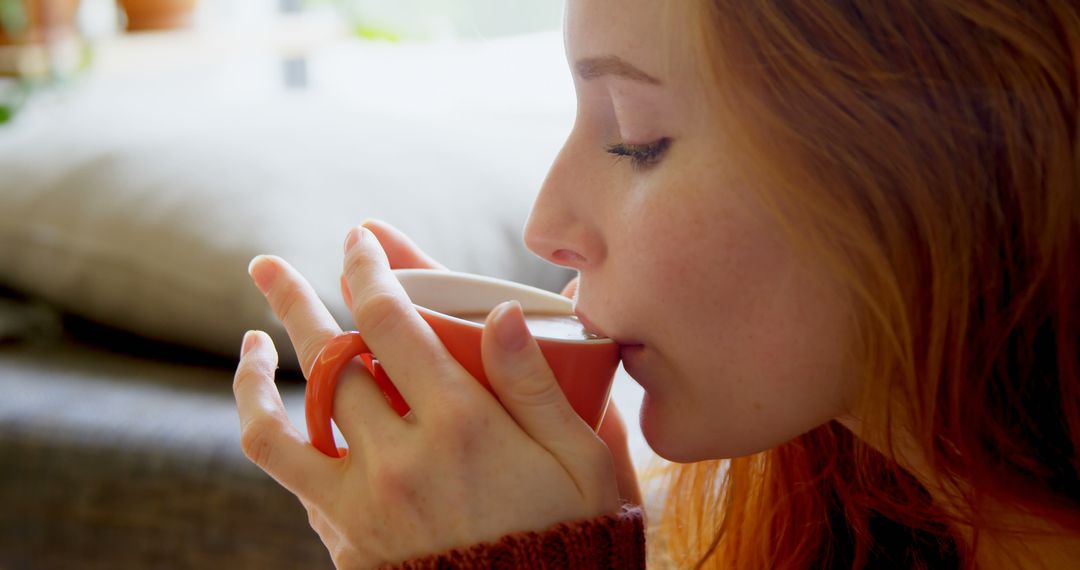 Young Woman Sipping Hot Coffee from Orange Mug - Free Images, Stock Photos and Pictures on Pikwizard.com