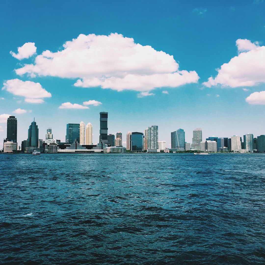 Scenic Urban Skyline Across Calm Waters on a Clear Day - Free Images, Stock Photos and Pictures on Pikwizard.com