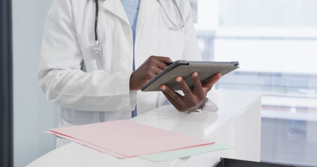 Doctor Using Digital Tablet at Reception Desk - Free Images, Stock Photos and Pictures on Pikwizard.com