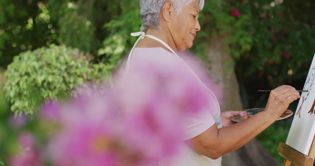 Senior Woman Painting Outdoors in Garden with Brushes - Free Images, Stock Photos and Pictures on Pikwizard.com