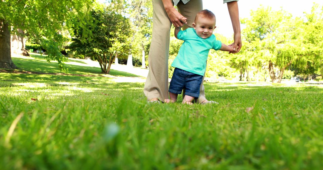 Mother Supporting Baby's First Steps on Lush Green Lawn - Free Images, Stock Photos and Pictures on Pikwizard.com