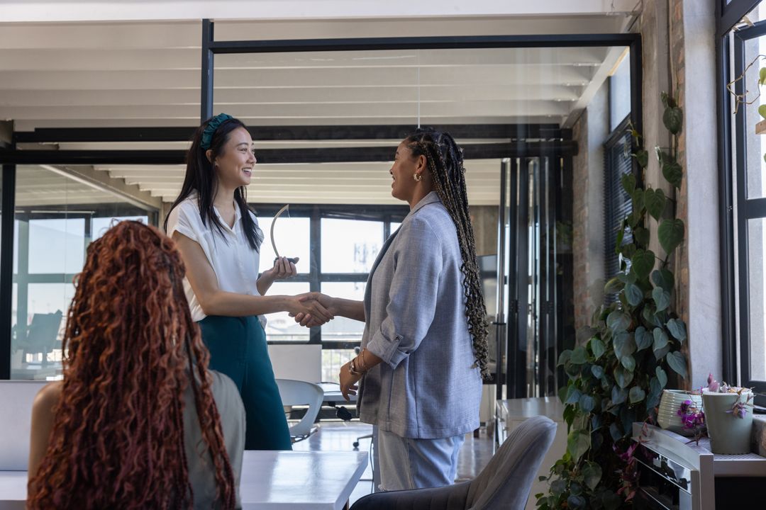 Diverse Colleagues Shaking Hands in Modern Office Workspace