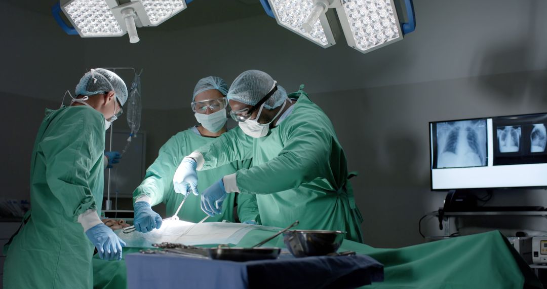 Focused diverse surgeons wearing face masks during surgery in operating room - Free Images, Stock Photos and Pictures on Pikwizard.com