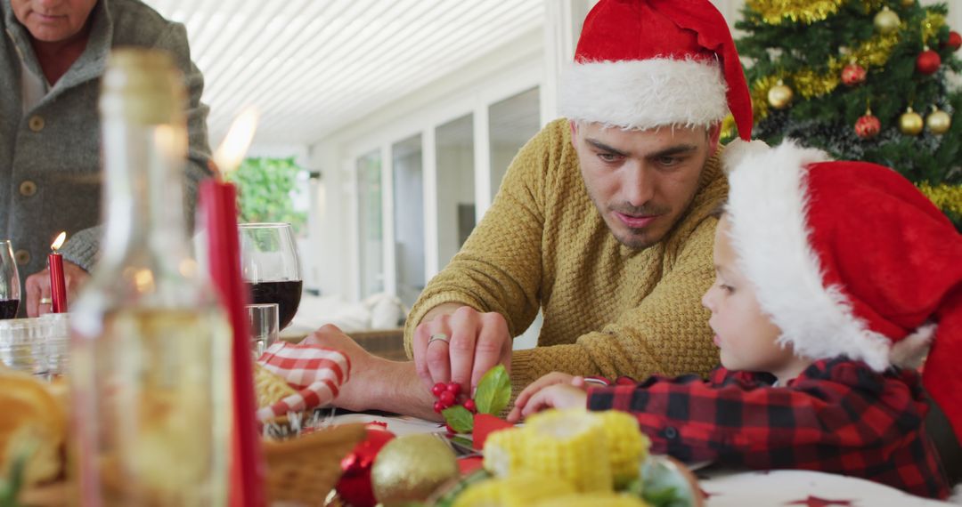 Father and Child Decorating Christmas Table Wearing Santa Hats - Free Images, Stock Photos and Pictures on Pikwizard.com