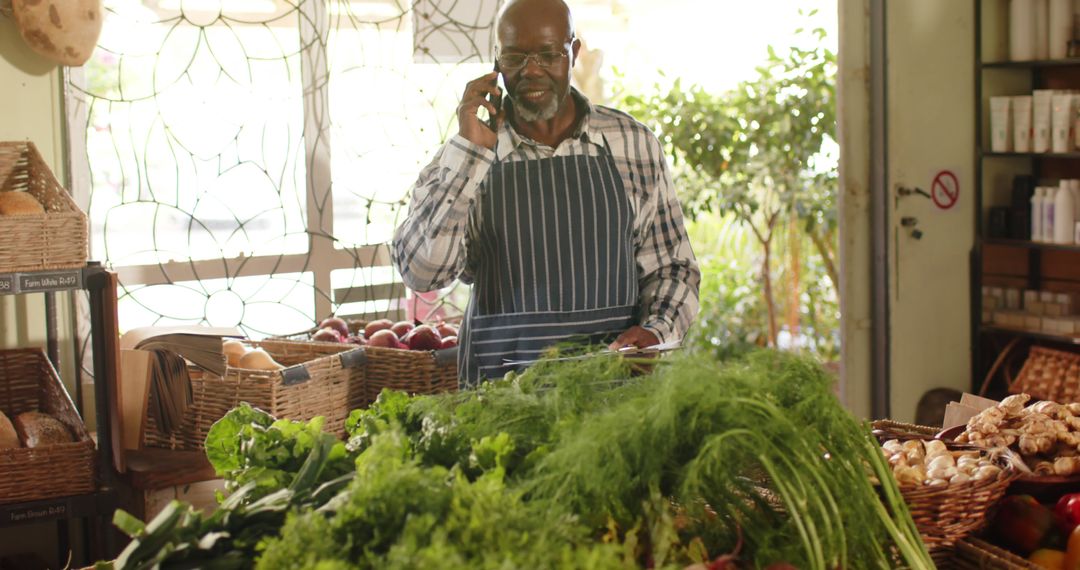 Senior male grocer managing store while talking on phone - Free Images, Stock Photos and Pictures on Pikwizard.com