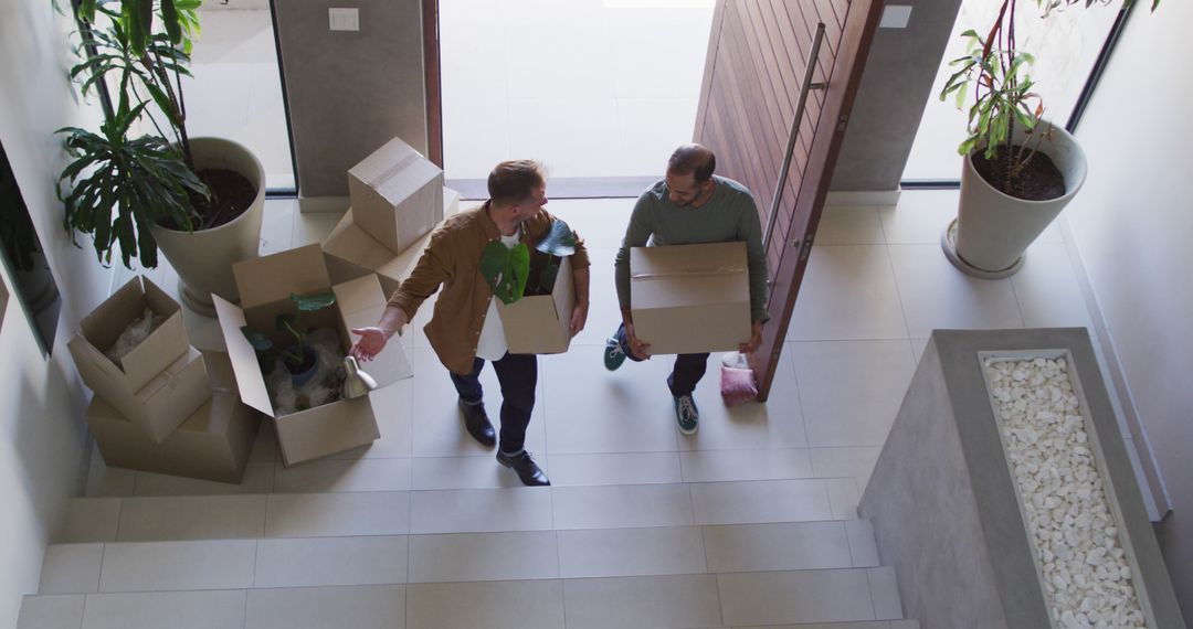 Two Men Carrying Boxes While Moving into New Home - Free Images, Stock Photos and Pictures on Pikwizard.com