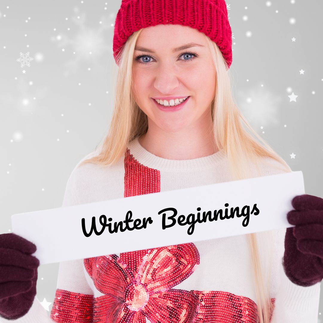 Smiling Woman Holding 'Winter Beginnings' Sign with Festive Background