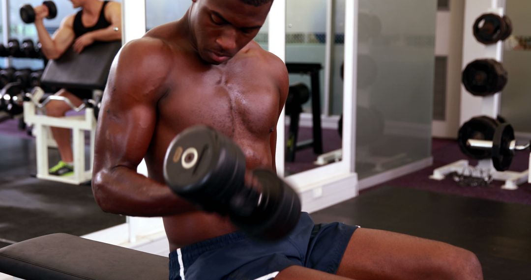 Fit young man lifting dumbbells in modern gym - Free Images, Stock Photos and Pictures on Pikwizard.com