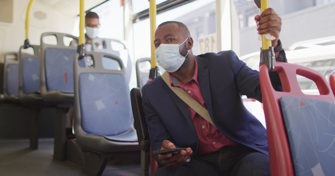 Man in Face Mask Using Smartphone on City Bus During Pandemic