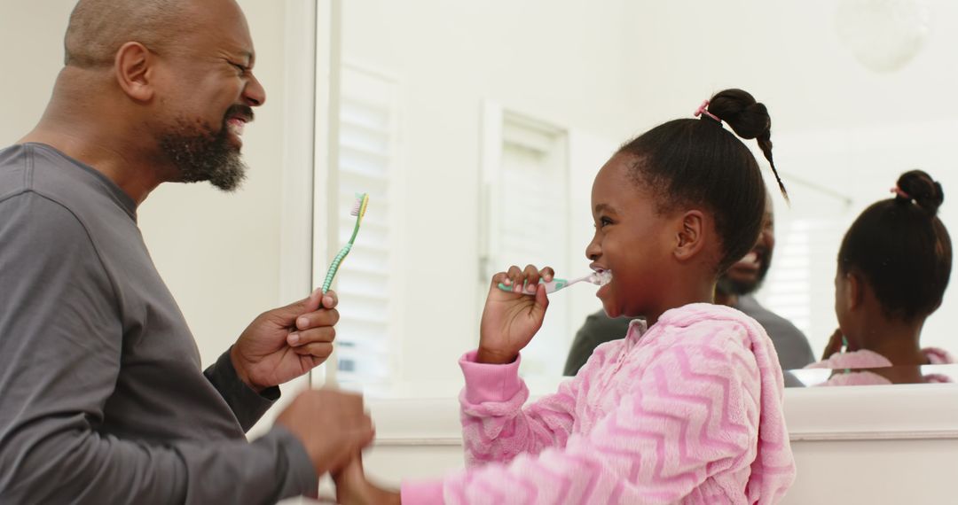 Father and Daughter Smiling Brushing Teeth Mirror Reflection