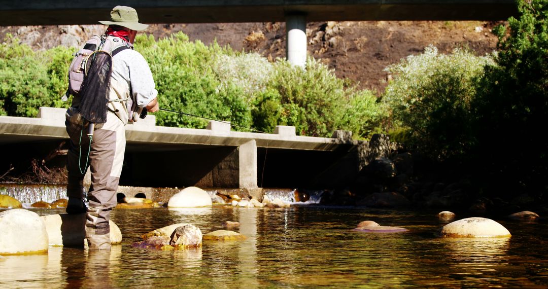 Man Fly Fishing in Mountain Stream Under Bridge - Free Images, Stock Photos and Pictures on Pikwizard.com