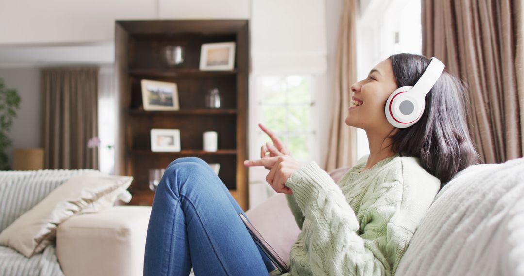 Young Woman Relaxing at Home with Headphones - Free Images, Stock Photos and Pictures on Pikwizard.com