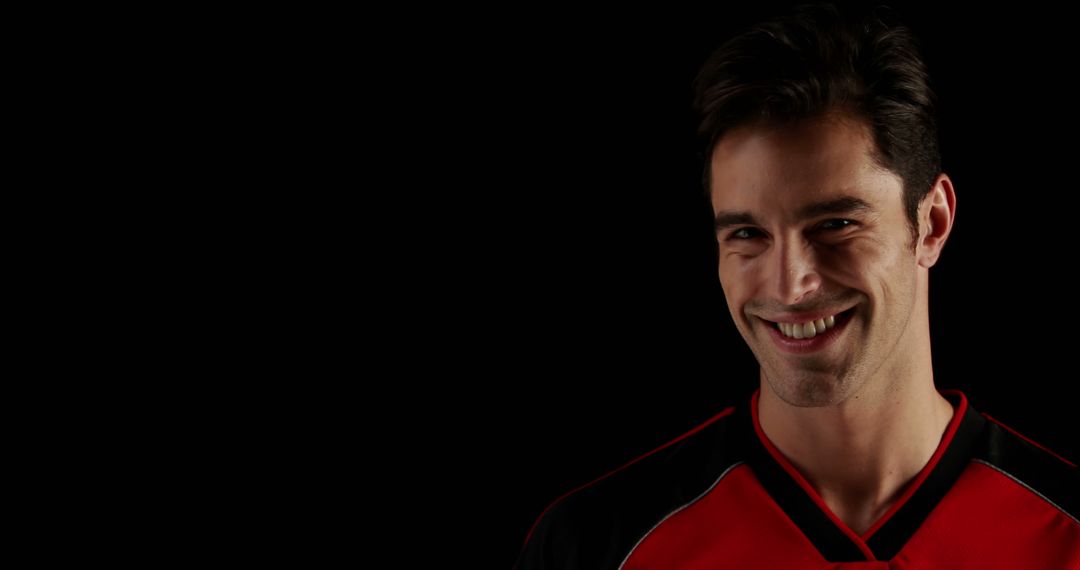 Smiling Athletic Man in Sports Jersey against Black Background - Free Images, Stock Photos and Pictures on Pikwizard.com