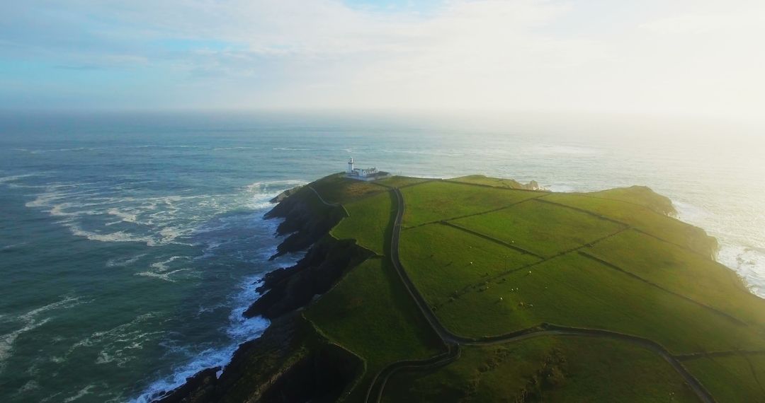 Drone View of Green Coastline with Lighthouse by Ocean - Free Images, Stock Photos and Pictures on Pikwizard.com