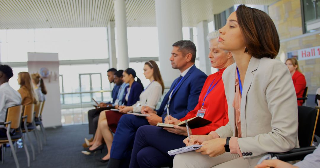Diverse Professionals at Business Seminar Taking Notes