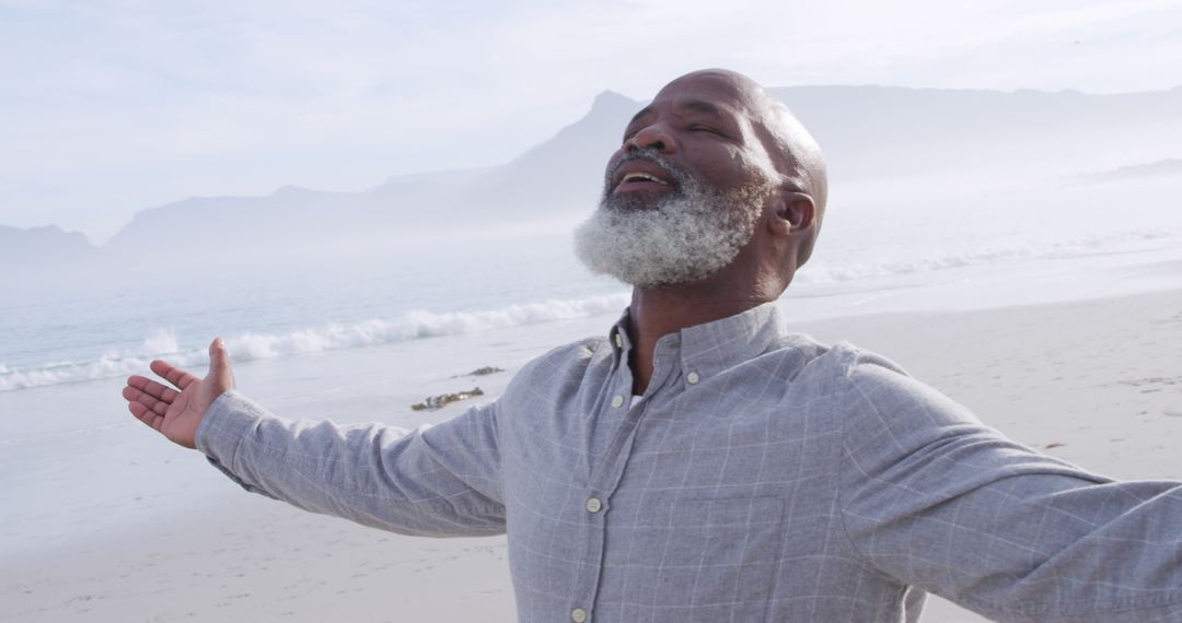 Elderly Man with Open Arms on Beach Enjoying Serenity - Free Images, Stock Photos and Pictures on Pikwizard.com