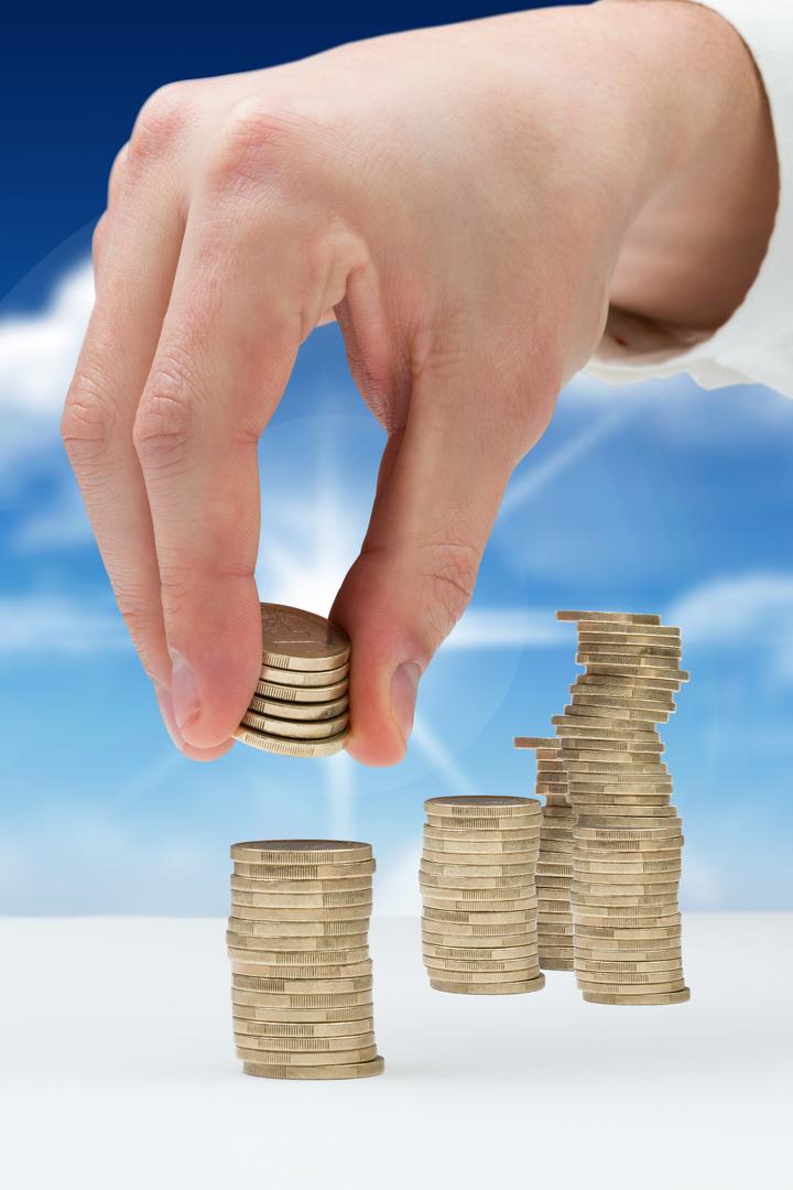hand stacking coins with sky background - Free Images, Stock Photos and Pictures on Pikwizard.com