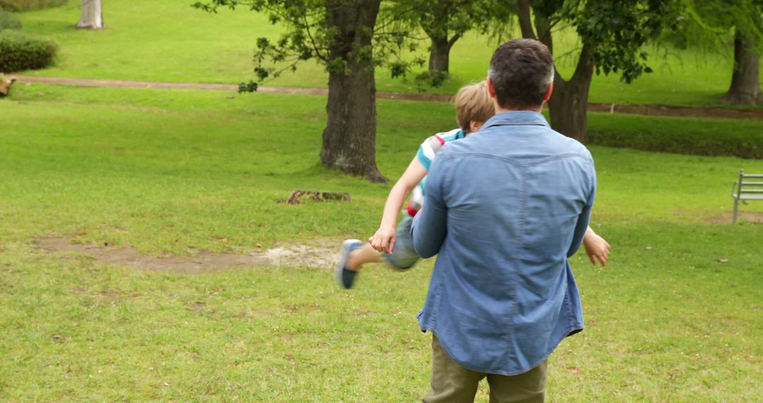 Father Hanging Child in Park on a Sunny Day - Free Images, Stock Photos and Pictures on Pikwizard.com