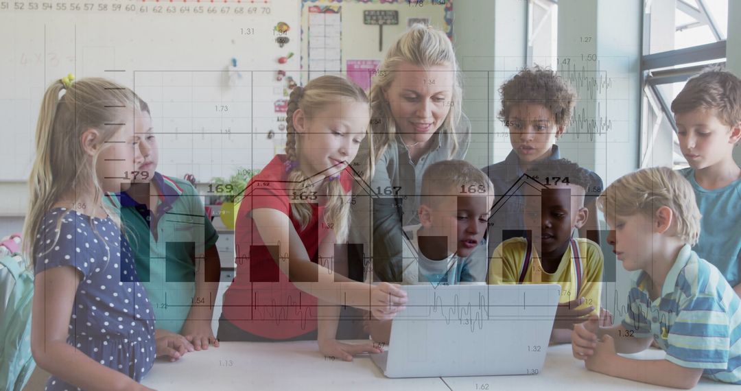 Teacher Guiding Enthusiastic Children in Classroom Learning on Laptop