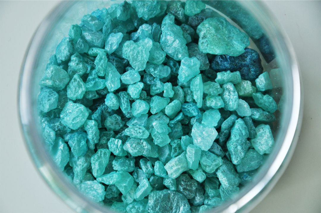 Vibrant turquoise rough crystals collected in glass bowl
