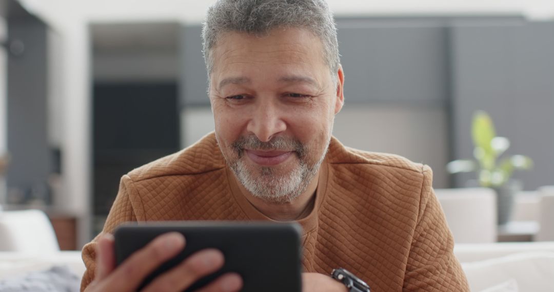 Elderly Man Smiling While Using Digital Tablet at Home - Free Images, Stock Photos and Pictures on Pikwizard.com