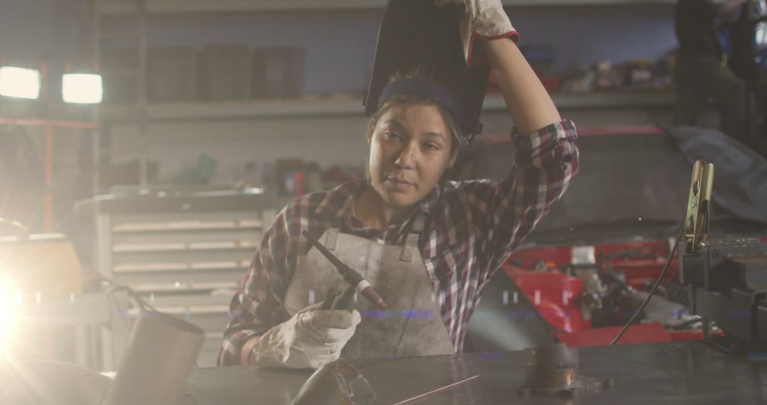 Female Mechanic Holding Welding Mask Taking Break in Workshop