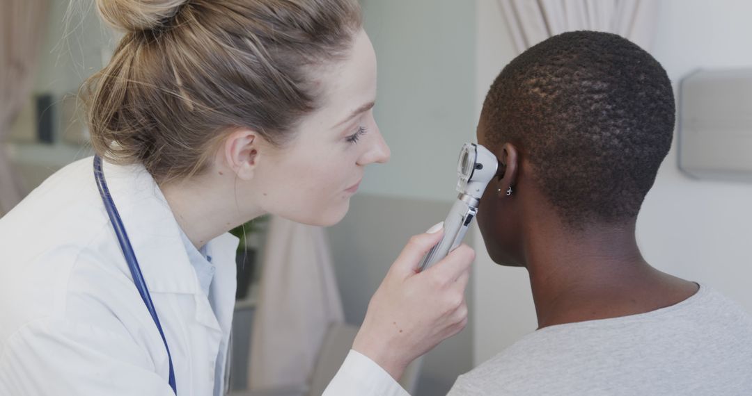 Doctor Examining Patient's Ear with Otoscope in Medical Center - Free Images, Stock Photos and Pictures on Pikwizard.com