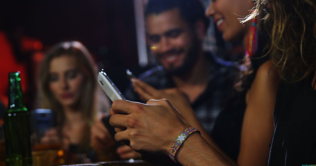 Young Adults Socializing in Bar with Smartphones