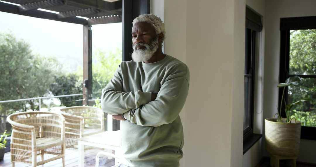 Mature Man Contemplating by Glass Door in Tranquil Home