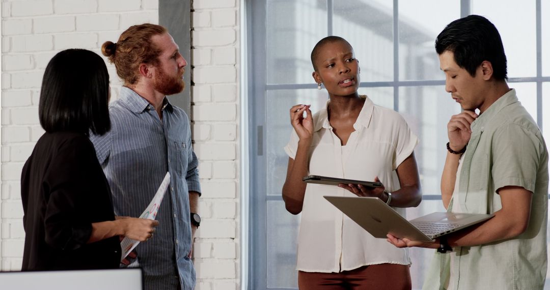 Diverse Team Collaborating in Modern Office with Tech and Documents